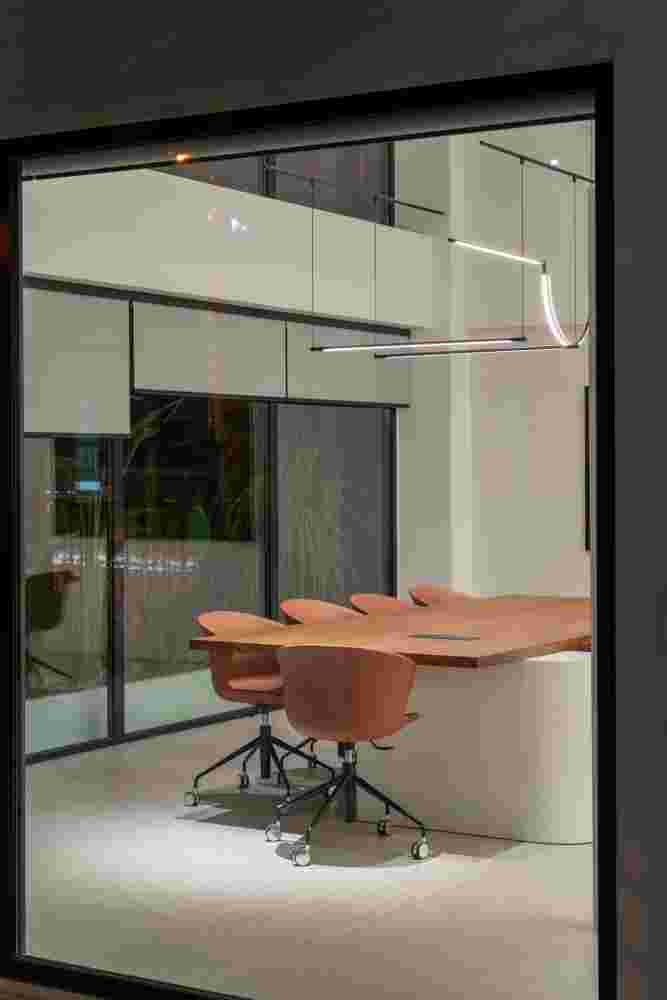 Exterior view of the central meeting room at night, with illuminated windows.