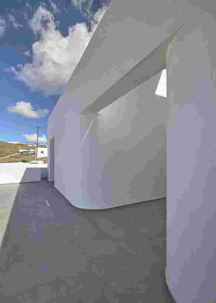 Curved corridor highlighted from the skylight and the shadows.