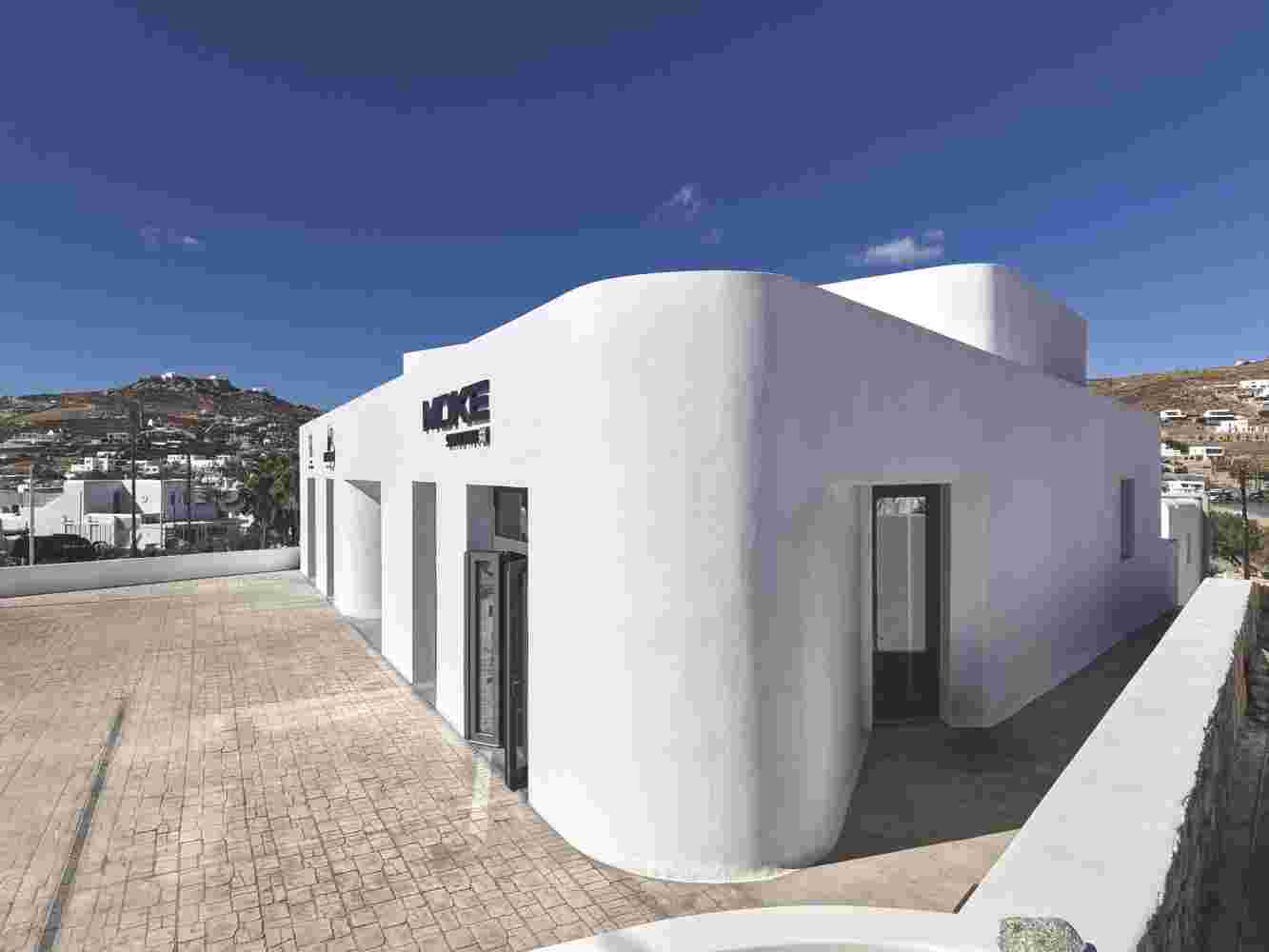 The curved corner of the building with a background of a deep blue Mykonos sky.